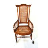 A Victorian beech bergere armchair, with shaped top rail, on brass castors, 109cm high