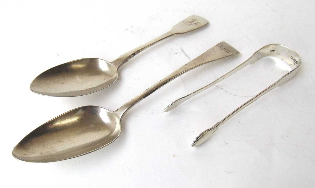 Two Georgian silver serving spoons together with a pair of silver sugar tongs. Various hallmarks.