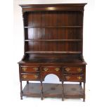 An early 20thn century reproduction oak Welsh dresser, the plate rack with boarded back, above the