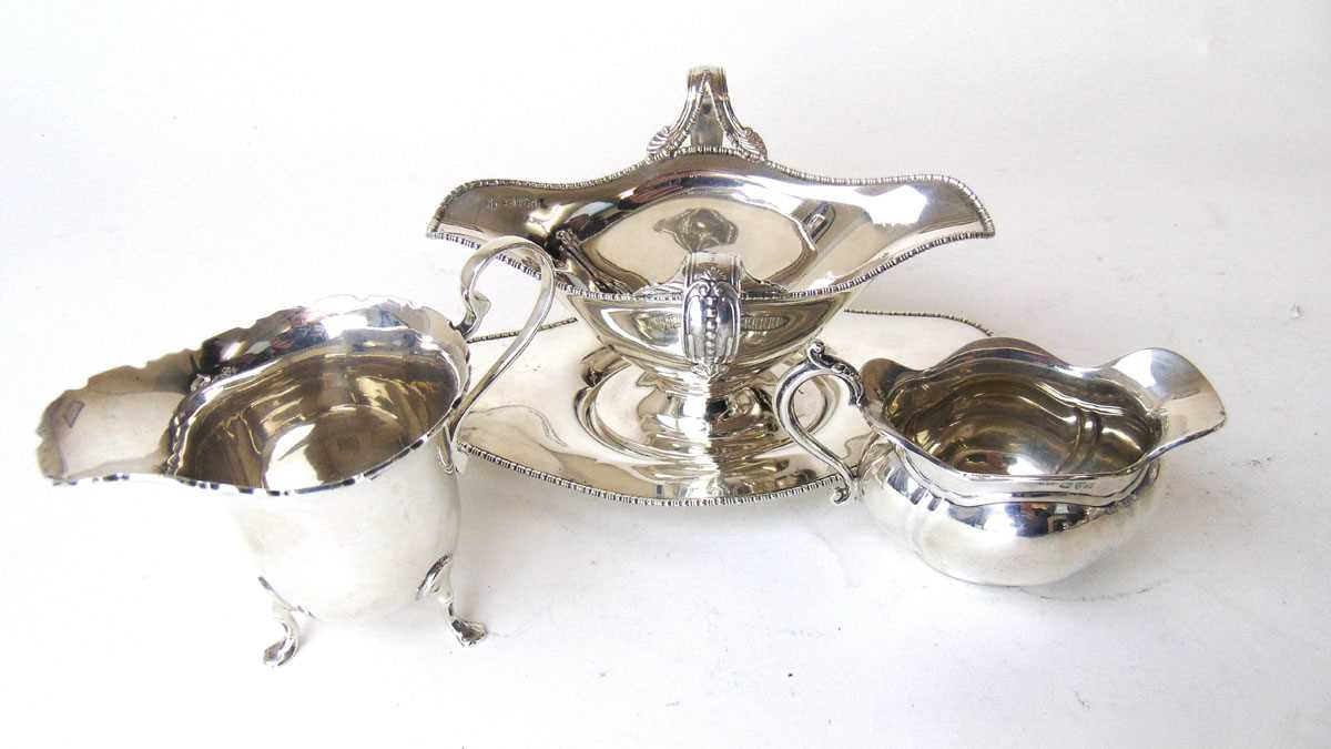 A silver double ended sauce boat and stand, Barker Bros, Chester 1908, the handles with beadwork and