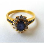 An 18ct gold sapphire and diamond cluster ring with channel set shoulders. Size N 1/2. Approx.