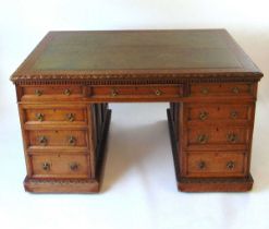 A late Victorian oak partners desk, with green tooled leather writing surface, above a series of