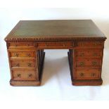 A late Victorian oak partners desk, with green tooled leather writing surface, above a series of