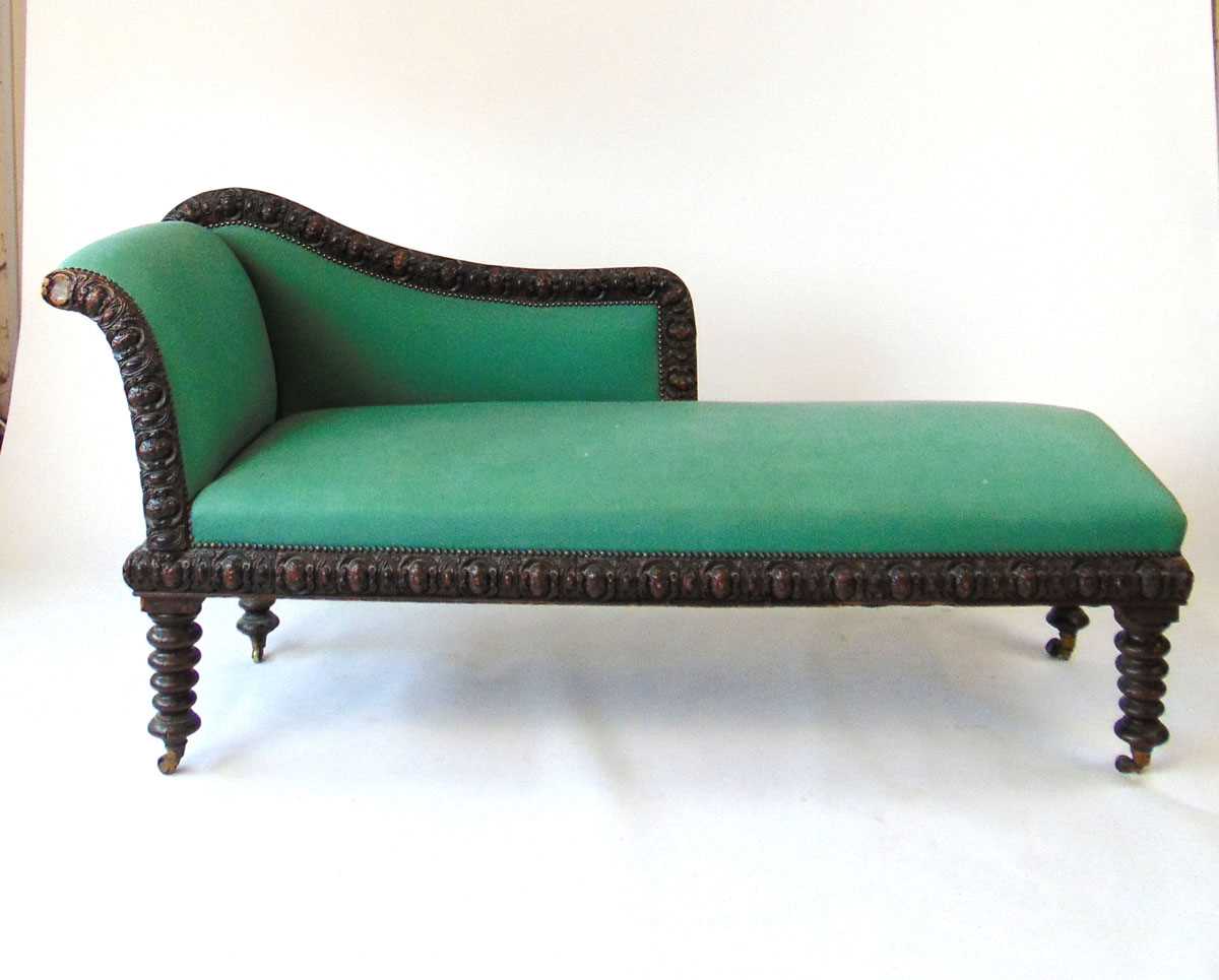 A 19th century oak chaise longue, the frame with a continuous band of oval foliate carved bosses,