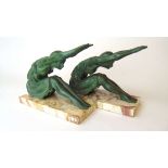 A pair of French Art Deco patinated spelter bookends, modelled as seated females dressed in open
