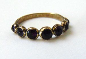 A 19th century yellow metal ring set with seven old cut amethysts. Size N. Approx. weight 1.9g A/F