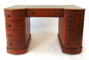 A late Victorian mahogany inverted breakfront desk, with tooled green leather writing surface, the