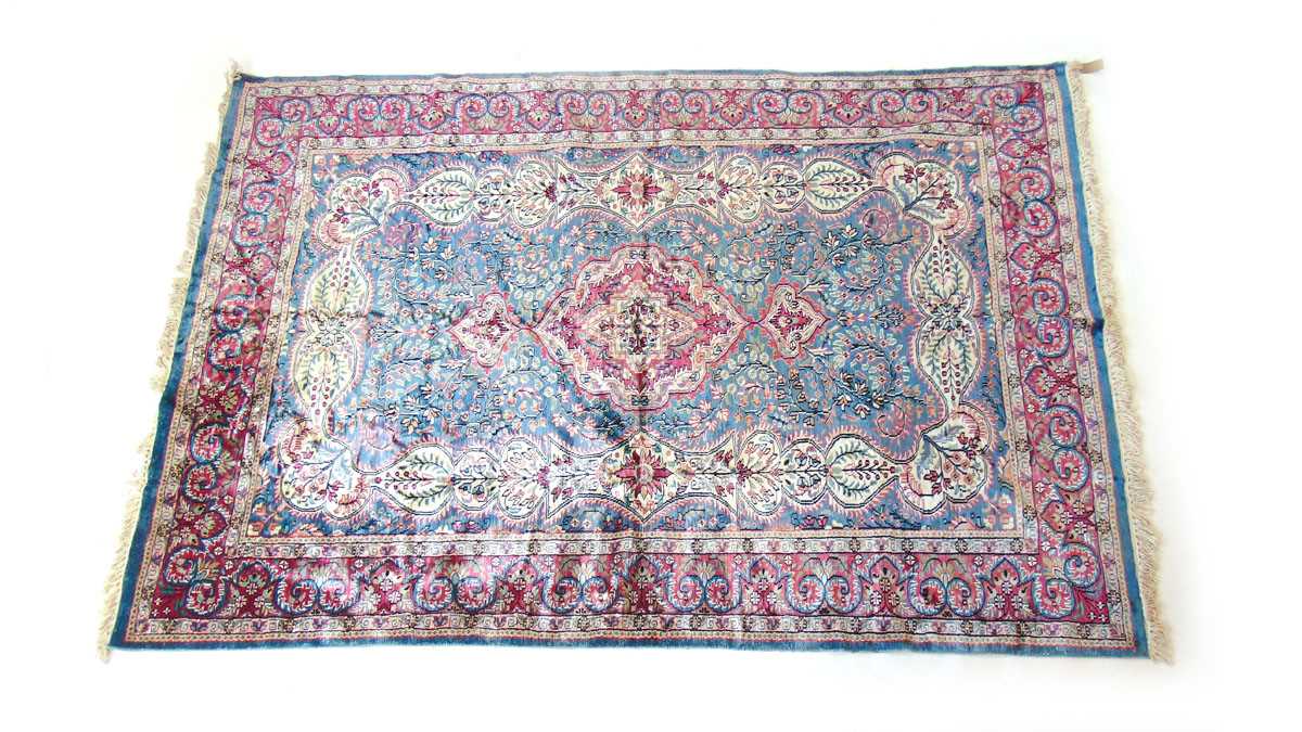 An Indian Tabriz style mercerised cotton rug, with central red and cream medallion against a pale