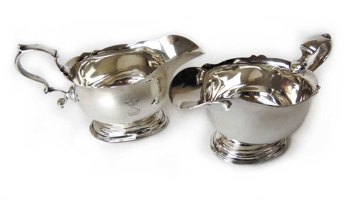 A pair of silver sauce boats, Daniel & John Wellby, London 1896 & 1899, with scroll handle on