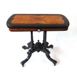 An Aesthetic period ebony and amboyna veneered card table, the top with shallow carved bellflower