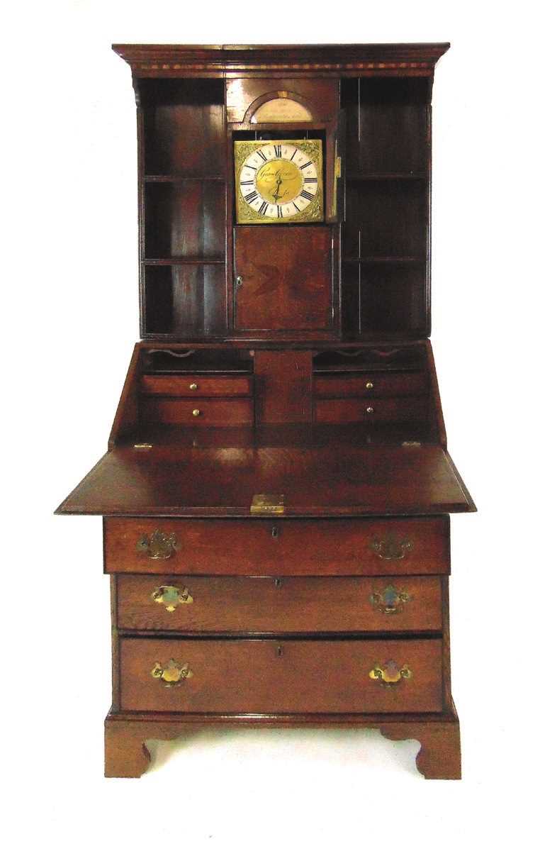 A George III oak bureau bookcase, the open bookcase top fitted with a 30 hour brass lantern clock,