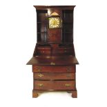 A George III oak bureau bookcase, the open bookcase top fitted with a 30 hour brass lantern clock,