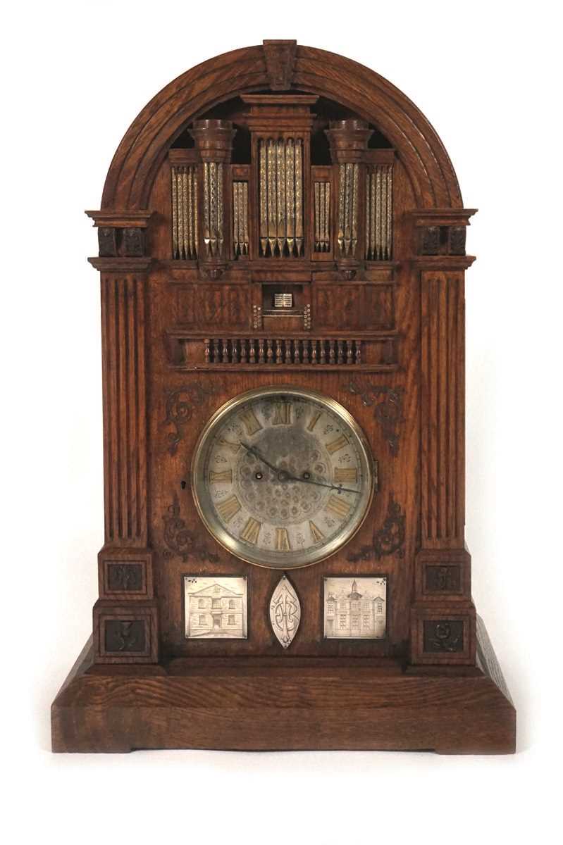 A late 19th century oak 'Church Organ' mantel clock. The top modelled as a pipe organ above reeded