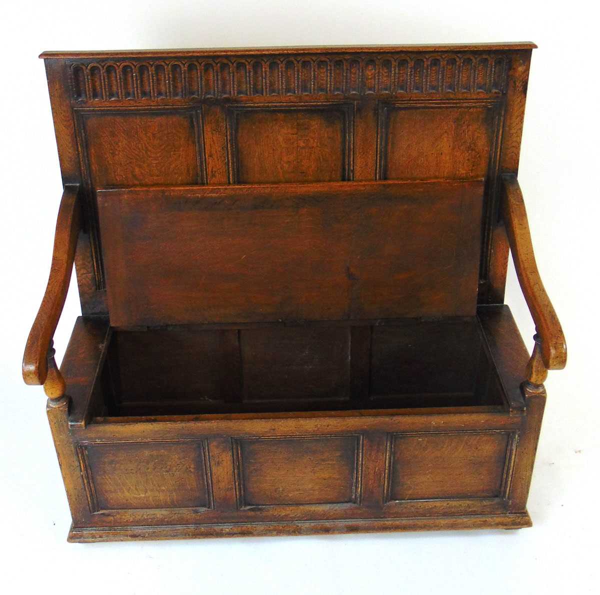 An early 20th century reproduction oak box settle, with a narrow arcaded frieze above three - Image 4 of 7