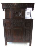 A 17th/18th century oak court cupboard, with stylised carved leaf frieze flanked by turned pendants,