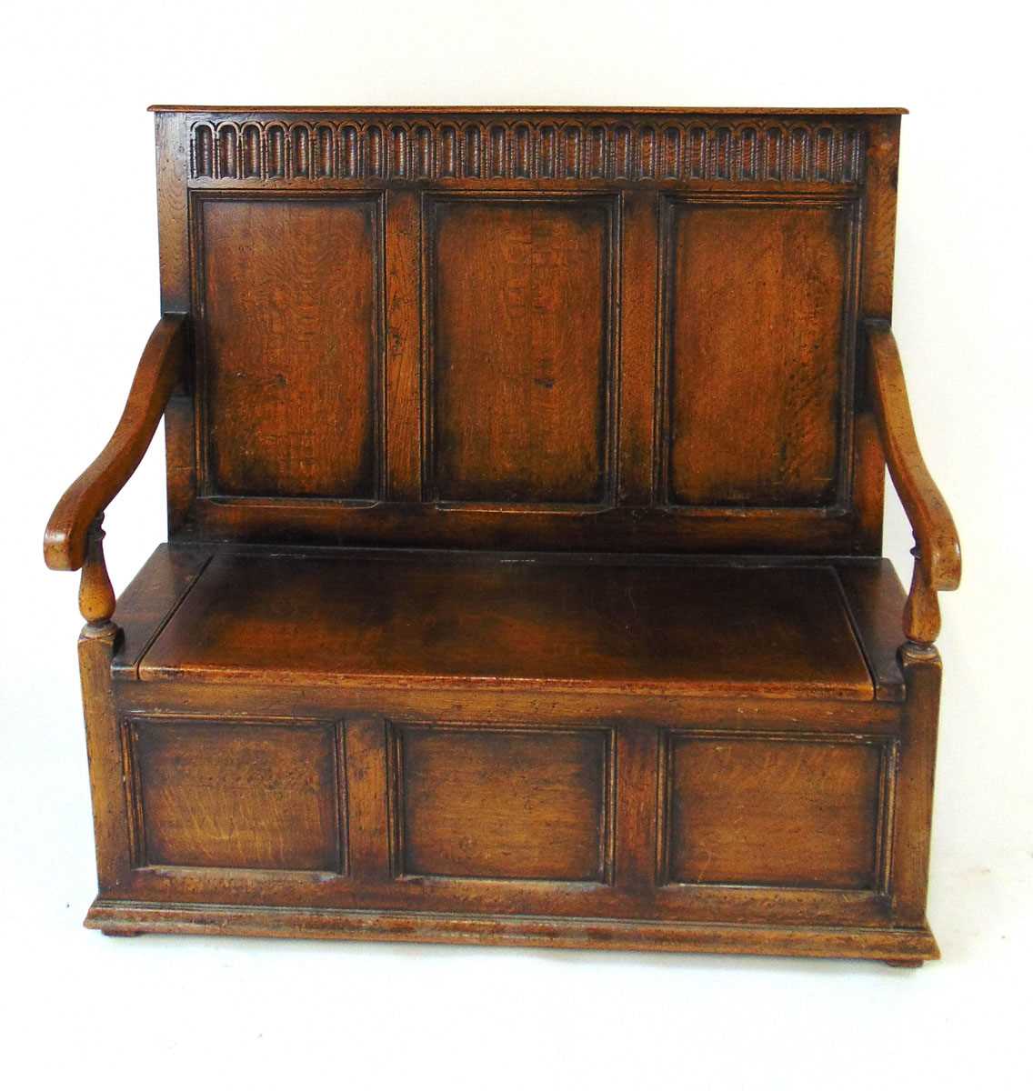 An early 20th century reproduction oak box settle, with a narrow arcaded frieze above three - Image 3 of 7