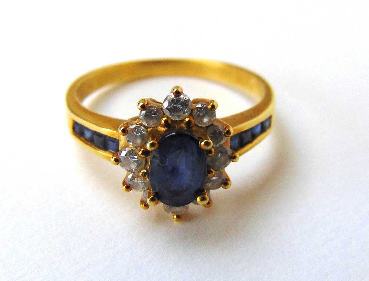 An 18ct gold sapphire and diamond cluster ring with channel set shoulders. Size N 1/2. Approx. - Image 2 of 2