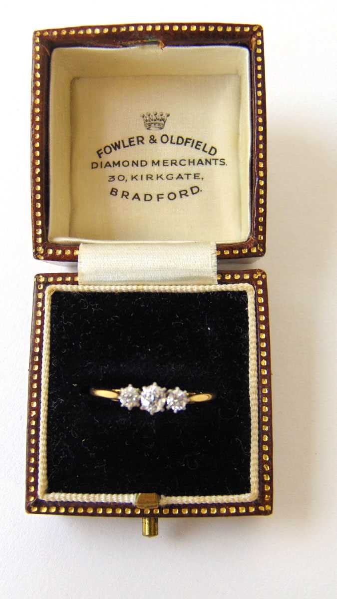 An early 20th century yellow metal and diamond trilogy ring marked '18ct'. The three old cut