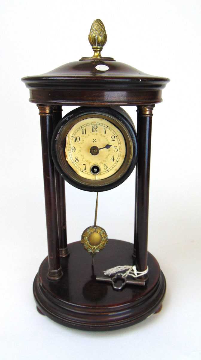 An early 20th century portico clock, with German movement, the dark stained body with brass acorn