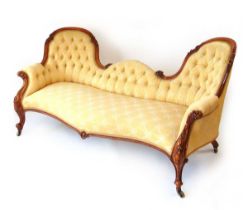 A Victorian conversation settee, with carved mahogany show frame, with horsehair and sprung filling,