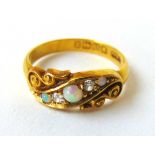 A late Victorian 18ct gold, opal and diamond ring the five stones in a scrollwork setting. Size M.