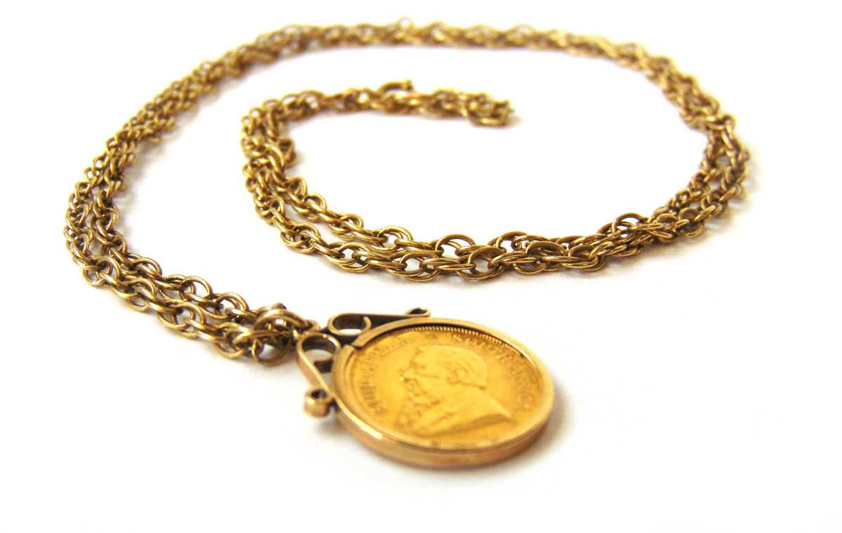 A South Africa 1980 1/10 oz Krugerrand in a 9ct gold pendant mounted suspended from a 9ct gold - Image 2 of 3