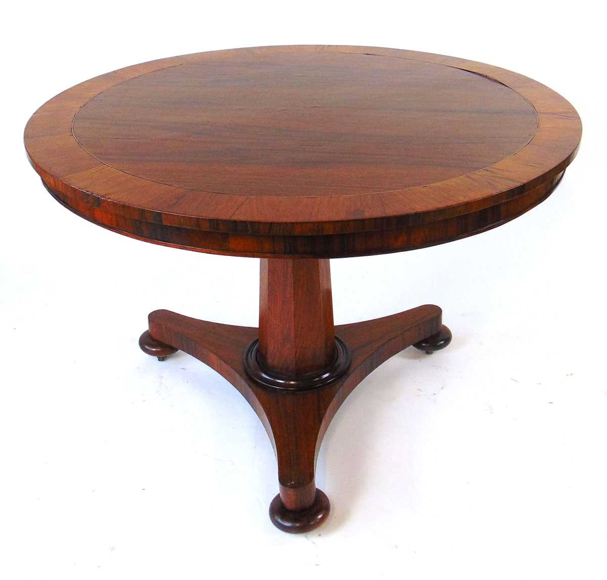 A 19th century rosewood tilt top table, with crossbanded edge and brass stringing, on an octagonal