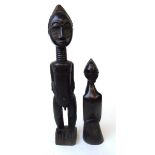 A Baule standing figure of a man, Ivory Coast, with carved coiffure, scarifications to his cheeks