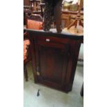 A George III oak wall mounted corner cupboard, with fielded panel door with medullary rays enclosing