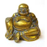 A cast brass figure of Hotei, the laughing buddha, cast with a smiling face and large exposed