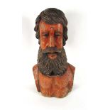 A large carved wood bust of a bearded man, painted in flesh tones with a faded dark brown beard