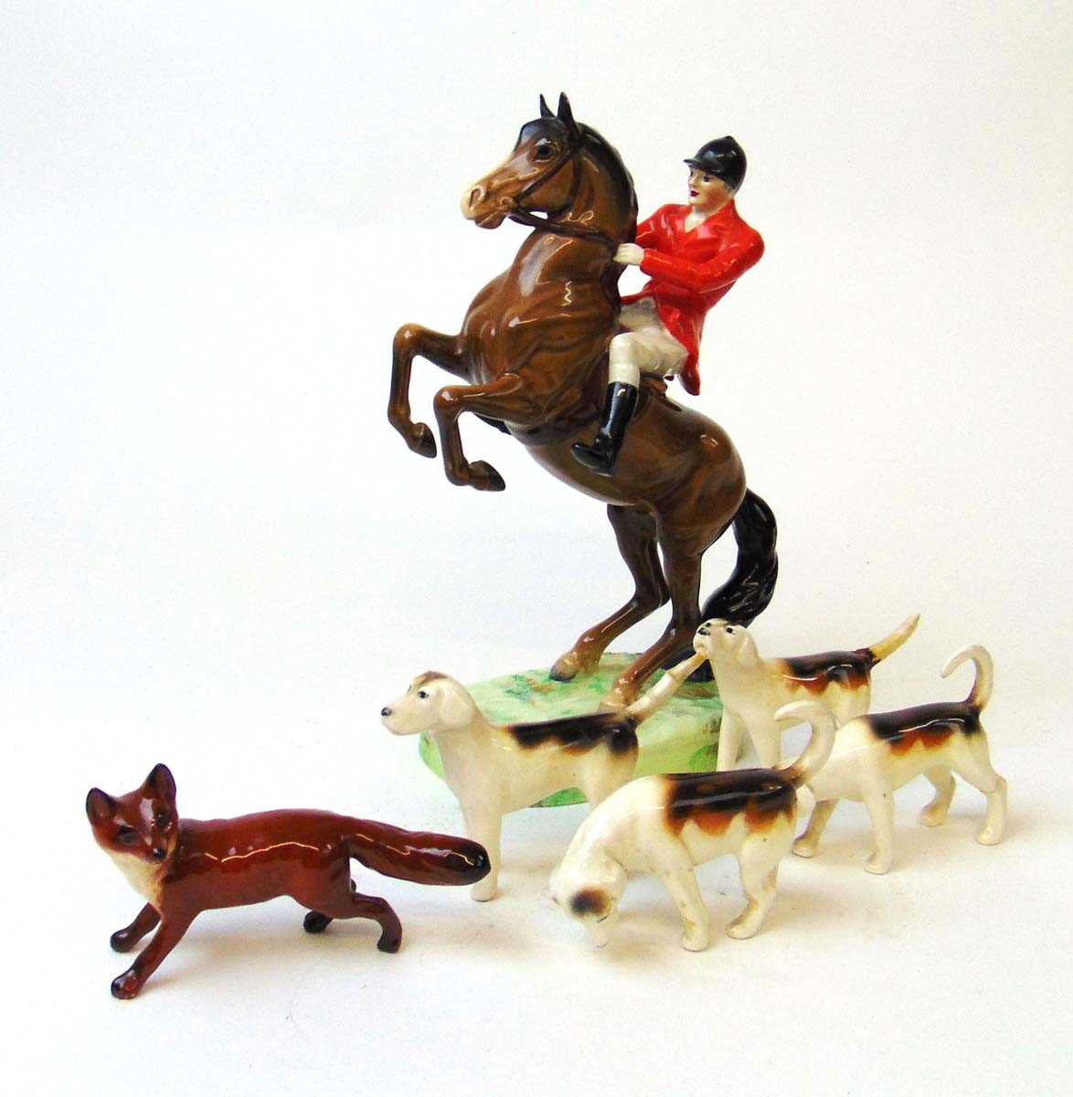 A Beswick figure of a huntsman on rearing horse, model 868, 24cm high, together with four hounds and