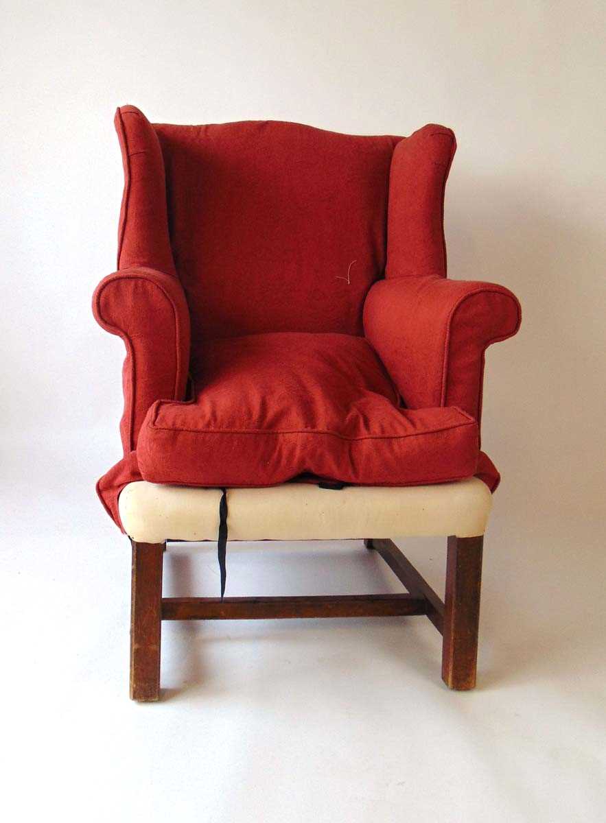 A 19th century George III style wing armchair, with square chamfered legs united by plain - Image 2 of 2