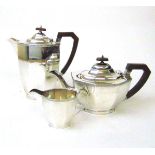 A silver three piece tea set, Lee & Wigfull, Sheffield 1934, the faceted body beneath a guilloche