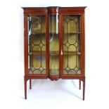 An Edwardian mahogany display case, with satinwood crossbanding and stringing, with bow front glazed