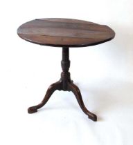 A George III oak tilt top occasional table, with turned support on three down swept legs, 73.5cm