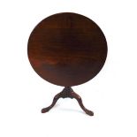 A George III mahogany tilt top occasional table, having a circular one piece top on turned support