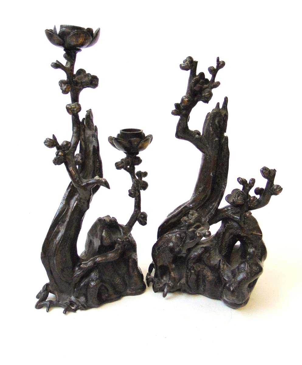 A close pair of Chinese style bronze candlesticks, 19th/20th century, of naturalistic form with a