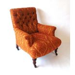 A Victorian upholstered armchair, with button back and scroll arm rests, with horsehair filling,