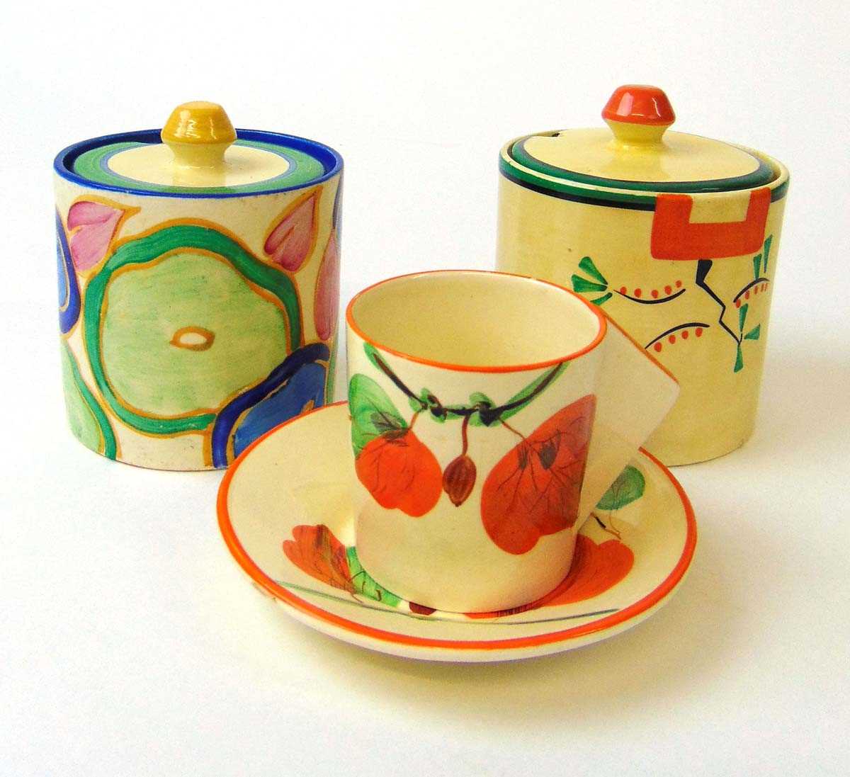 Two Clarice Cliff 'Bizarre' preserve pots in Ravel & Chintz patterns, and a Honeyglaze coffee can