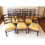 A set of ten George III style mahogany ribbon back dining chairs, with stuff over seats on channeled