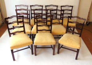 A set of ten George III style mahogany ribbon back dining chairs, with stuff over seats on channeled