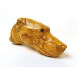 An early 20th century faux ivory walking stick handle formed as a dogs head, with inset glass eye (