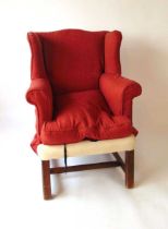 A 19th century George III style wing armchair, with square chamfered legs united by plain