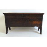 A 17th century oak coffer, the top with moulded edge and interior candle box, the front with a