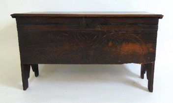 A 17th century oak coffer, the top with moulded edge and interior candle box, the front with a