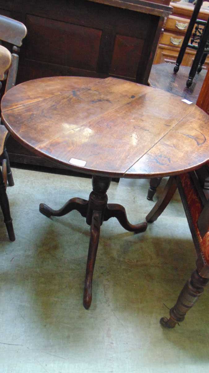 A George III oak tilt top occasional table, with turned support on three down swept legs, 73.5cm