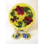 A large Walter Moorcroft hibiscus pattern charger and a pair of pansy pattern dressing table