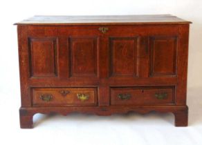 A George III oak mule chest, the three plank top above four recessed panels and two short drawers