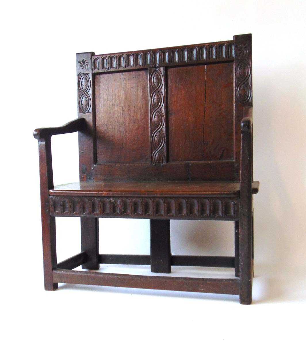 An 18th century and later oak settle, with arcaded top rail flanked by carved wheel and figure of - Image 3 of 3